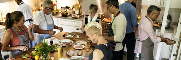 A group of people in a kitchen making food.