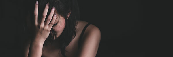 A lady with her head in her hand in a depressed way.