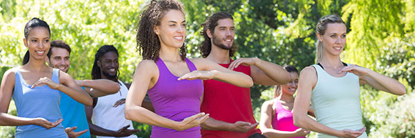 A group of people doing a Tai Chi Pose.